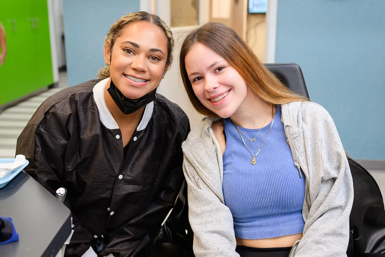 Dental professional and patient smiling together in a pediatric dental office, showcasing a friendly atmosphere and child-friendly environment.