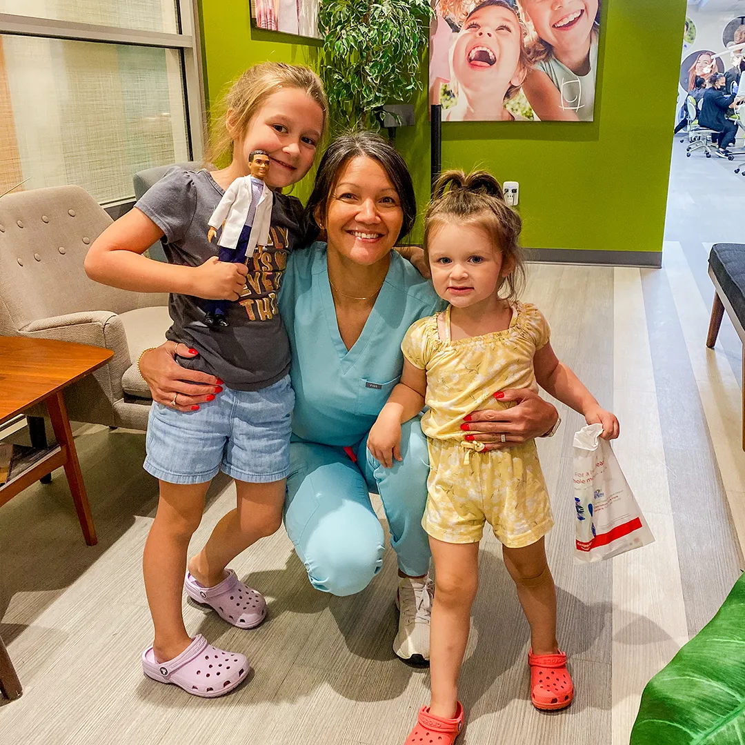 Mother and daughters sharing a warm embrace at Behl Orthodontics