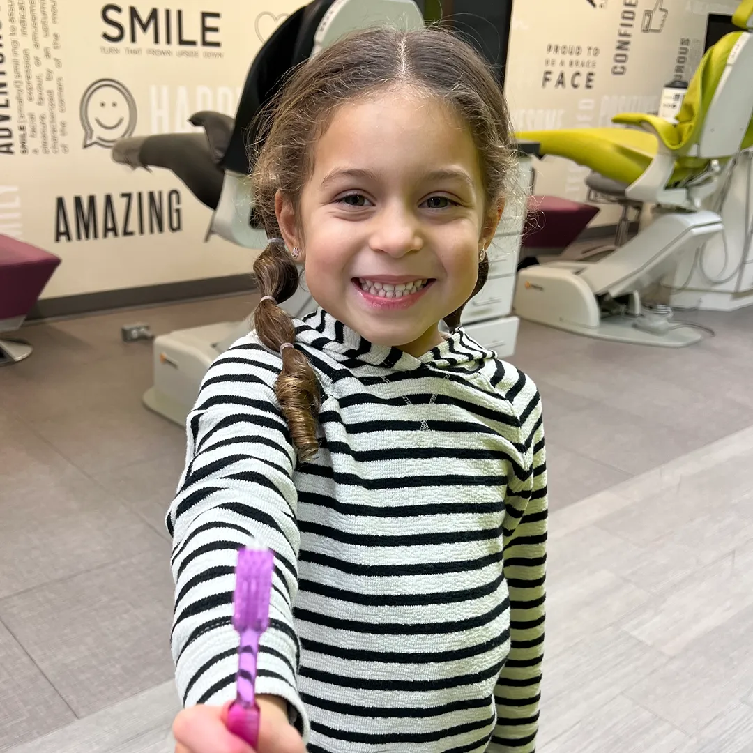 Young patient with toothbrush promoting good oral hygiene at Behl Orthodontics
