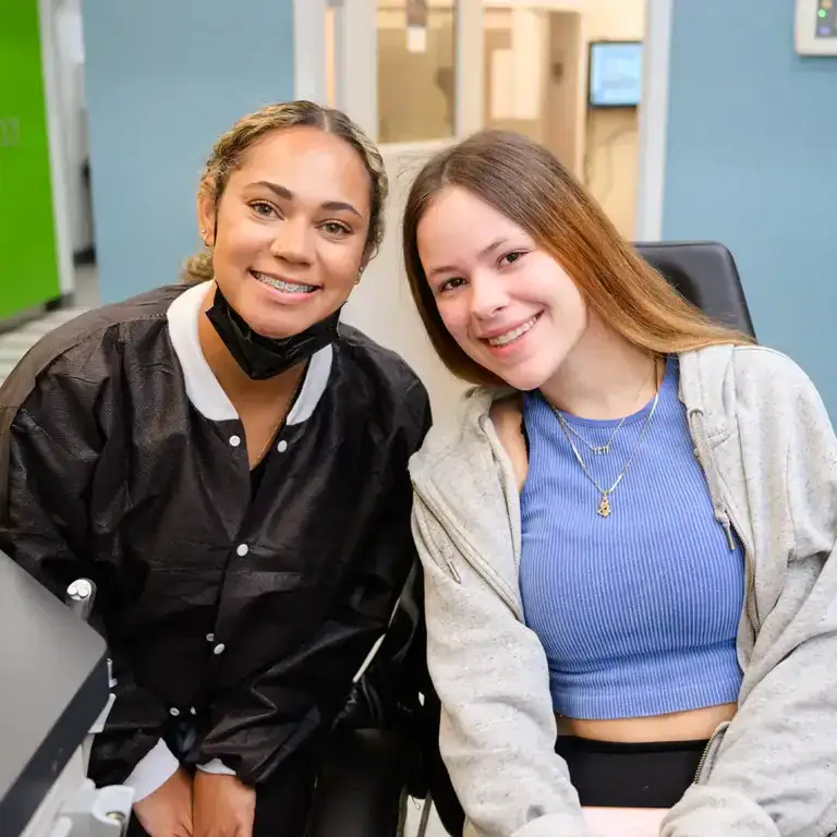 Friendly orthodontic assistant and smiling patient with braces at Behl Orthodontics